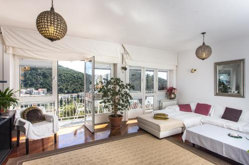 a living room with a white couch and a large window at Villa Pušić in Dubrovnik