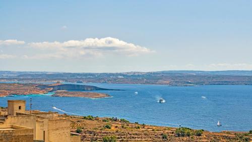 a view of a large body of water with a boat at Ta' Dun Martin and taz-Zija Bed and Breakfast in Nadur