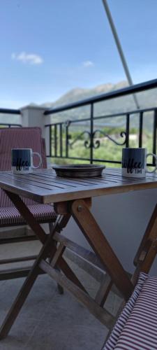 a wooden table and two chairs on a balcony at Olivo Nydri in Nydri