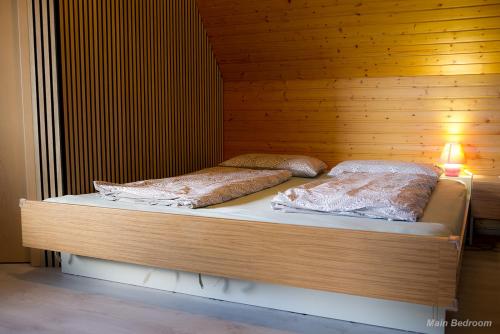 two beds in a room with a wooden wall at 71 square meters Condo in Schwarzwald with beautiful mountain view, free wifi in Schonwald im Schwarzwald