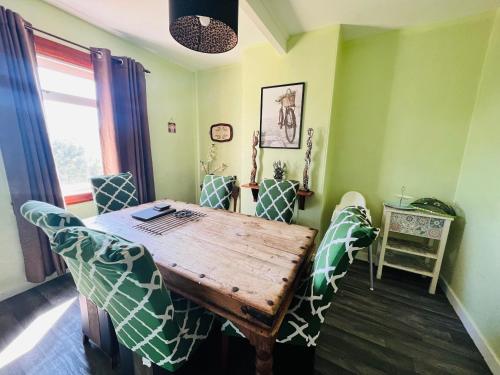 a dining room with a wooden table and chairs at Park Road Holiday Home in Rosyth