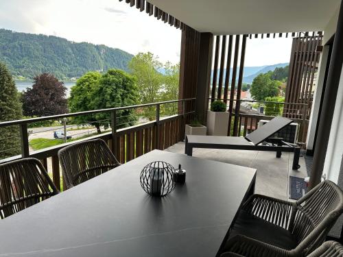 a table and chairs on a balcony with a view at Apartment Deluxe Ossiacher See - Gerlitzen in Sattendorf