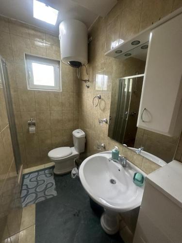 a bathroom with a sink and a toilet and a mirror at Villa mit wunderschönem Meerblick in Dobra Voda