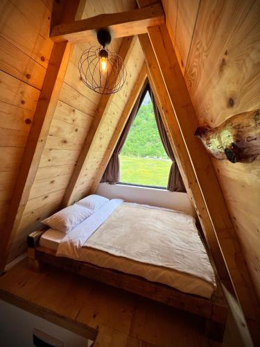 a bedroom in a tree house with a window at Natures Escape Kozarica in Šavnik