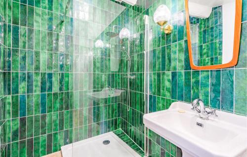 ein grün gefliestes Bad mit einem Waschbecken und einer Dusche in der Unterkunft Amazing Home In Mdis With Private Swimming Pool, Can Be Inside Or Outside in Médis
