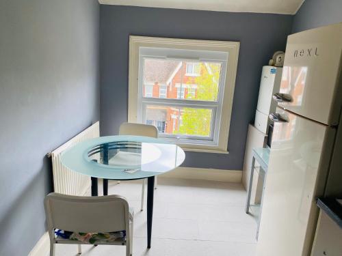 a small kitchen with a table and a refrigerator at 2nd floor shared flat near Bedford train station in Bedford