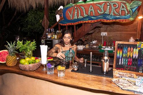 a woman standing at a bar making a drink at Villa Yira Eco-hotel in El Zaino