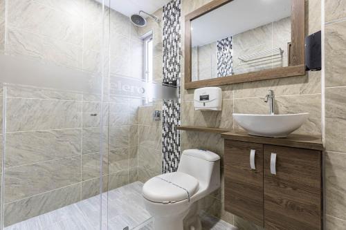 a bathroom with a toilet and a sink at Hotel Velero in San Antonio de Pereira