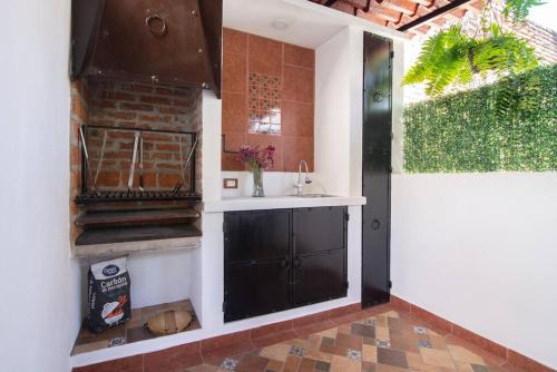 eine Küche mit einem Waschbecken und einer Theke mit einem Fenster in der Unterkunft Ursus, Mi casita en México in Mexiko-Stadt