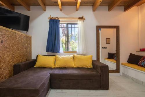a living room with a brown couch and a mirror at Ursus, Mi casita en México in Mexico City