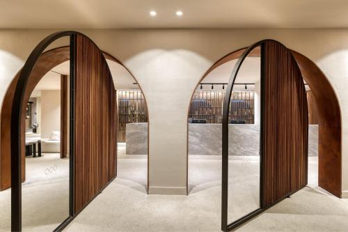 a hallway with two large mirrors in a room at Domes of Corfu, Autograph Collection in Glyfada