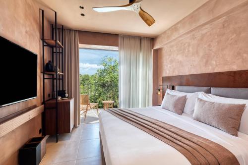 a bedroom with a large bed and a television at Domes of Corfu, Autograph Collection in Glyfada