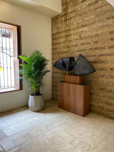 a living room with a lamp and a plant at Alko Hotel Casa Nispero in Cali