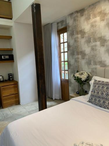 a bedroom with a white bed and a window at Alko Hotel Casa Nispero in Cali