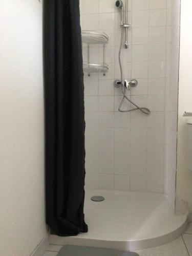 a shower with a black shower curtain in a bathroom at Maison Caroual Erquy 500m de la PLAGE in Erquy