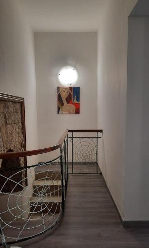 a room with a staircase with a painting on the wall at La Llua Alghero in Alghero