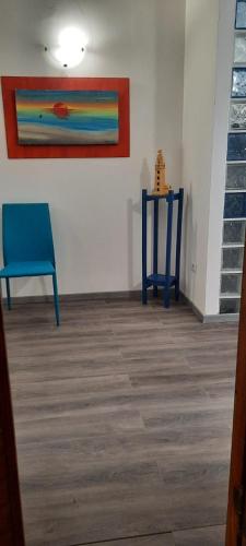a room with a blue chair and a table at La Llua Alghero in Alghero
