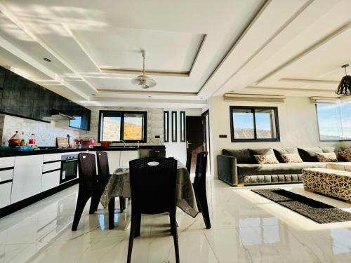 Il comprend une cuisine et un salon avec une table et des chaises. dans l'établissement SUNFLOWER Apartments, à Agadir nʼ Aït Sa