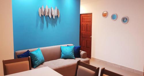 a living room with a couch and a blue wall at Villa del Mar Departamento 1 I in Salinas