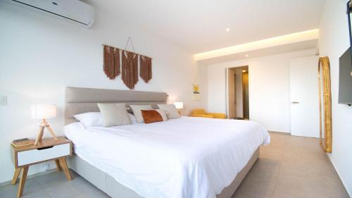 a white bedroom with a large white bed in it at Brand New Condo Aria Ocean 614 by Kivoya in Nuevo Vallarta