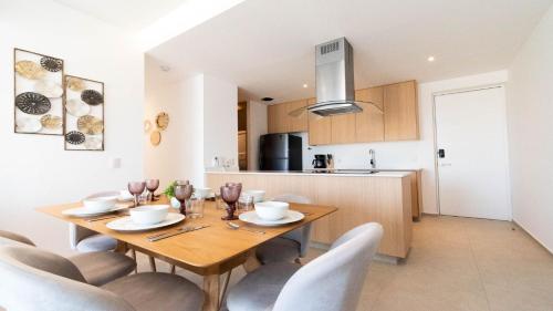 a kitchen and dining room with a wooden table and chairs at Brand New Condo Aria Ocean 614 by Kivoya in Nuevo Vallarta 