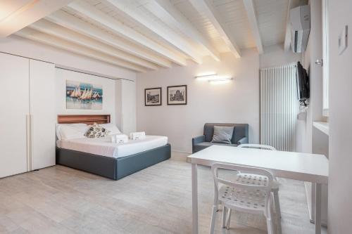 ein Schlafzimmer mit einem Bett, einem Tisch und einem Stuhl in der Unterkunft Vicolo Zini Apartments in Verona