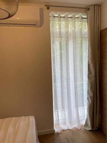 Cette chambre dispose d'une fenêtre avec des rideaux blancs. dans l'établissement Appartement centre ville Corte (F), à Corte