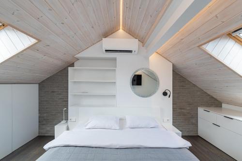 um quarto com uma grande cama branca e clarabóias em Luxury 2 BD Apartment with terrace by Hostlovers em Kaunas