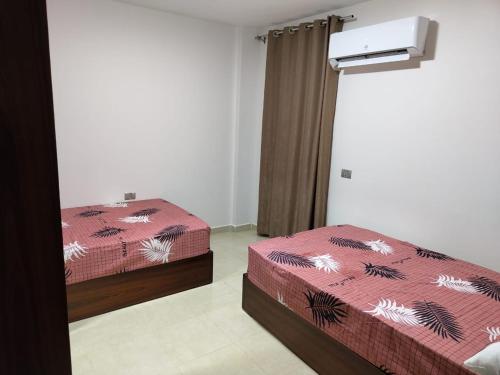 um quarto com 2 camas e uma janela em شاليه 120/202 مارينا دلتا em Al Ḩammād