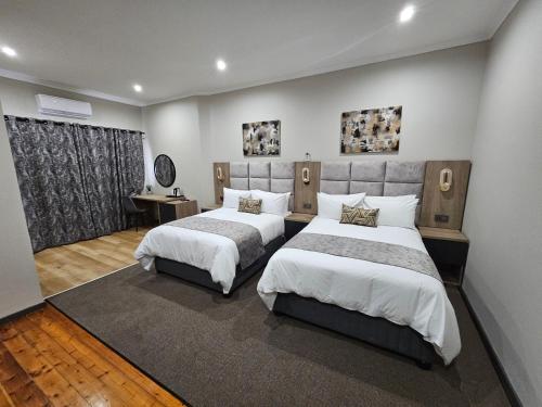 a hotel room with two beds and a window at Luxe Musgrave Boutique Hotel in Durban