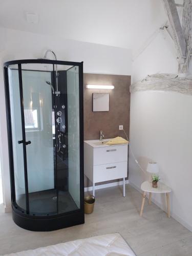 uma casa de banho com uma cabina de duche em vidro e um lavatório. em Chez cococuisine em Les Nouillers