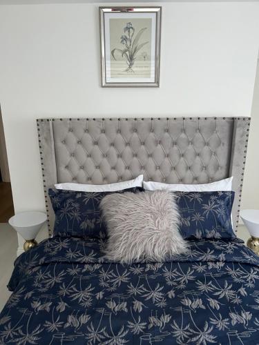 een slaapkamer met een blauw bed met een grijs hoofdeinde bij PRECIOUSHOUSELUXURYSTAY in Londen