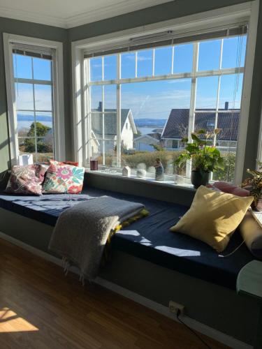 a bed in a room with a large window at Shared Farmhouse in Stavanger