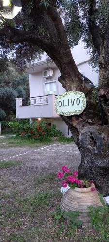 un cartel en un árbol delante de una casa en Olivo Nydri en Nydri