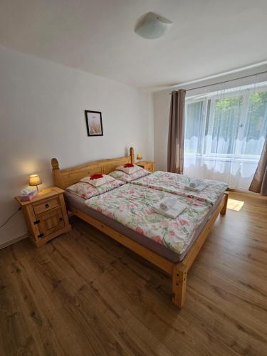 um quarto com uma cama, uma mesa e uma janela em Apartmán u Labe em Děčín