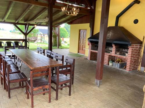 a wooden table and chairs and a brick fireplace at Pension Hofberg in Jetřichovice