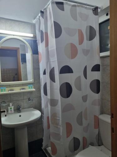 a bathroom with a sink and a shower curtain at White rose in Kámpos