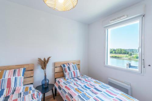 une chambre avec un lit et une fenêtre dans l'établissement Appartement Saint Goustan : Vue sur la rivière, à Auray