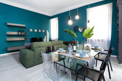 - un salon avec un canapé vert et une table dans l'établissement The Suite Home Verona, à Vérone