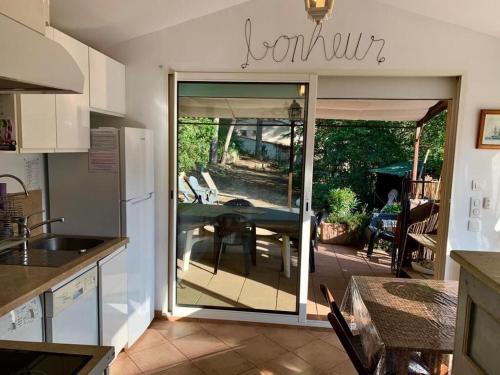 d'une cuisine avec une porte coulissante en verre s'ouvrant sur une terrasse. dans l'établissement BANDOL-MAISON LA BIENVENUE 9MN A PIED MER-CALANQUE PORT D'ALON-GRAND JARDIN+FIBRE WIFI, à Saint-Cyr-sur-Mer