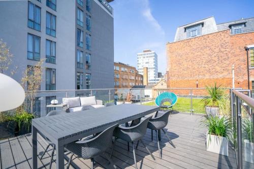 a patio with a table and chairs on a balcony at Chic City Centre Penthouse in Leicester