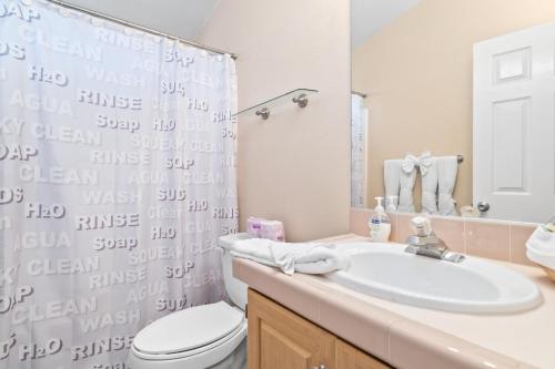 a bathroom with a sink and a toilet and a shower at Wine Down - Beautiful and well-kept cabin with large fenced back yard in Big Bear City