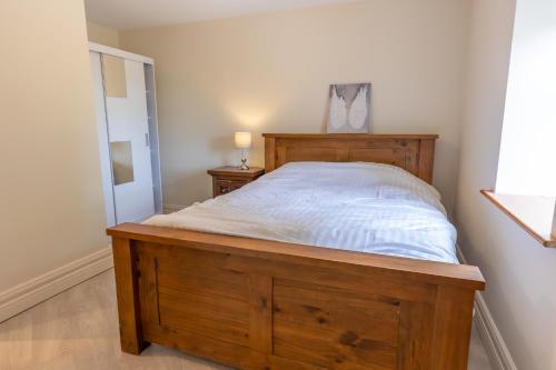 a bedroom with a wooden bed in a room at Bellair House in Cluain na Slí