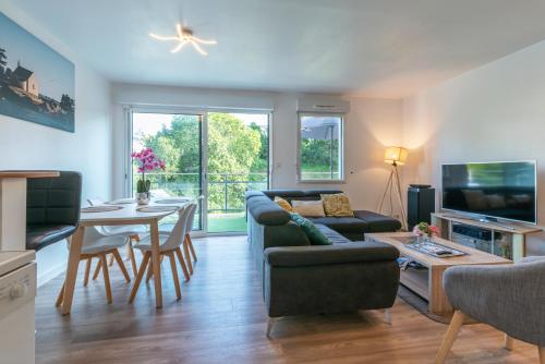 un salon avec un canapé et une table dans l'établissement Appartement Saint Goustan : Vue sur la rivière, à Auray
