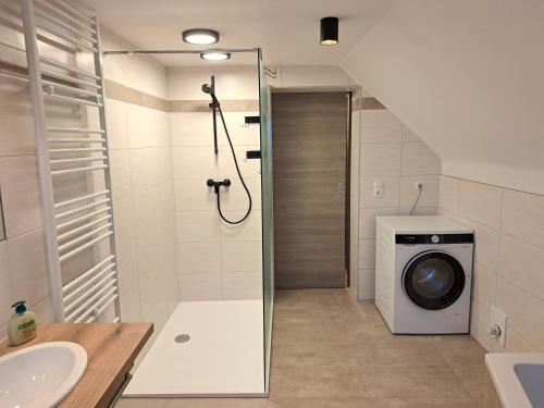 a bathroom with a shower and a washing machine at Gasthof Knappenwirt in Mariahof