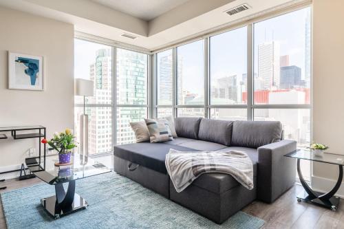a living room with a couch and large windows at Luxury 1BR Condo - King Bed - Stunning City Views in Toronto