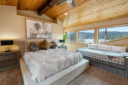 1 Schlafzimmer mit 2 Betten, einem Schreibtisch und Fenstern in der Unterkunft Boulder Bay Chalet Lakefront - Elegantly decorated with Hot Tub and Game Room! in Big Bear Lake