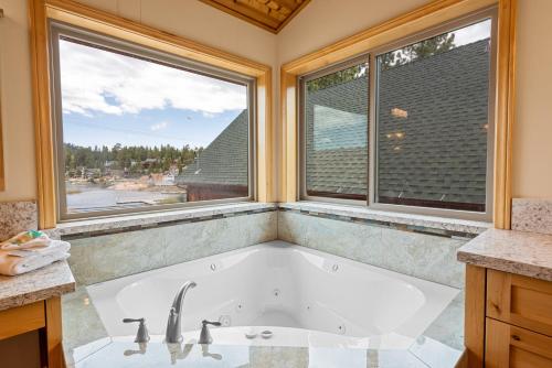 eine Badewanne im Bad mit 2 Fenstern in der Unterkunft Boulder Bay Chalet Lakefront - Elegantly decorated with Hot Tub and Game Room! in Big Bear Lake