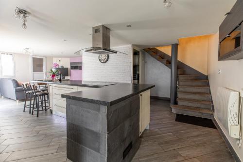 a kitchen with a counter top and a staircase at Les Lilas - Confort - Calme - Wifi in Volvic