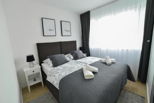 a bedroom with a bed with two towels on it at New and modern apartment BaRoNi in Split